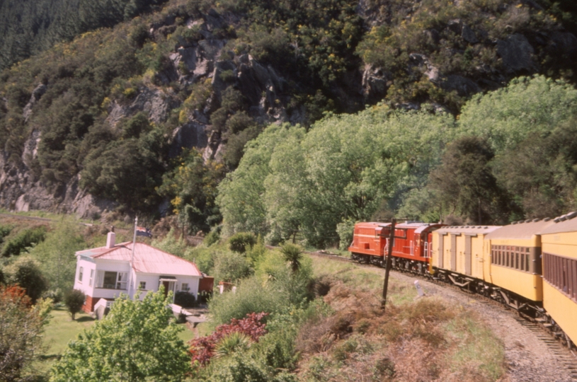 131625: Approaching Parera Taieri Gorge Railway Passenger to Middlemarch De 504 Dj 1240 and former railway house