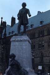 401201: Ottawa ON Canada Statue of Thomas D'Arcy McGee at rear of Housesof Parliament